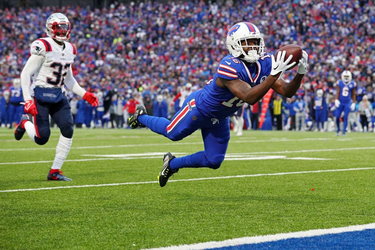 ORCHARD PARK, NEW YORK - JANUARY 08: John Brown #16 of the Buffalo Bills catches a touchdown pass while Devin McCourty #32 of the New England Patriots watches during the third quarter at Highmark Stadium on January 08, 2023 in Orchard Park, New York. (Photo by Bryan M. Bennett/Getty Images)